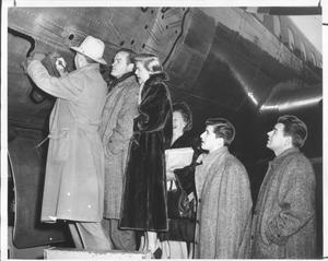 Primary view of object titled '[Bob Hope, Doris Day, and other performers writing their autographs on an airplane]'.