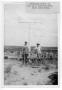 Primary view of [Two men erecting a wooden cross near Glen Lake Camp]
