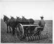 Primary view of [A man using cultivating equipment.]