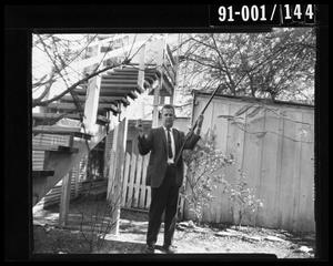 Primary view of object titled 'Detective Brown with Rifle in Backyard at 214 Neeley Street #2'.