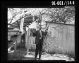 Photograph: Detective Brown with Rifle in Backyard at 214 Neeley Street #2