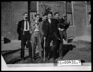 Primary view of object titled 'Five Men in Suits Standing Outside by a Building'.