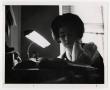 Primary view of [Photograph of Woman Studying by Lamp Light]