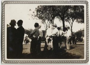 Primary view of object titled '[Crowd of people standing under trees]'.