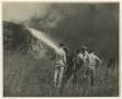 Photograph: [Photograph of Firemen Spraying Wood Pile]