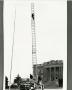Photograph: [Photograph of Fire Truck with a Man on its Ladder]