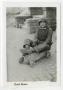 Photograph: [Earl Akers Sitting on a Toy Go-Cart]