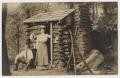 Postcard: [Postcard with Couple Leaning on a Log Cabin]