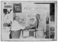 Photograph: [Lyndon Johnson Shaking Hands under a Post Office Display]
