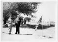 Photograph: [Two Men with Cigars by a Flag]