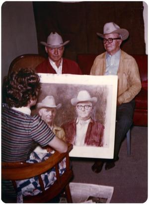 Primary view of object titled '[Allison Joy with a Portrait of the Two Men Sitting in Front of Her]'.
