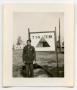 Photograph: [A Soldier Standing in Front of a Sign]
