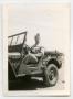 Photograph: [Photograph of H. K. Wells in Jeep]