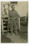 Photograph: [A Soldier Standing in Front of a Small Staircase]