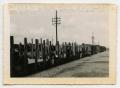 Photograph: [German Soldiers Sitting on Flatbed Rail Cars]
