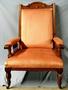 Physical Object: [Eastlake golden oak armchair with orange fabric, torn corner]
