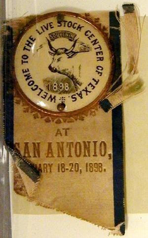 Primary view of object titled '[Button with ribbonreads "WELCOME TO THE LIVE STOCK CENTER OF TEXAS, SOUVENIR, 1898"]'.