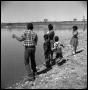 Primary view of [Children Fishing off of a Rocky Bank]