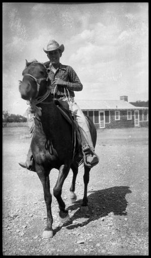 Primary view of object titled '[Boy on Horseback in Front of Brick Building]'.
