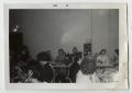 Primary view of [Photograph of Men and Women Sitting at Tables]