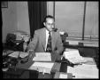 Photograph: Attorney Dean Moorhead in office smoking pipe