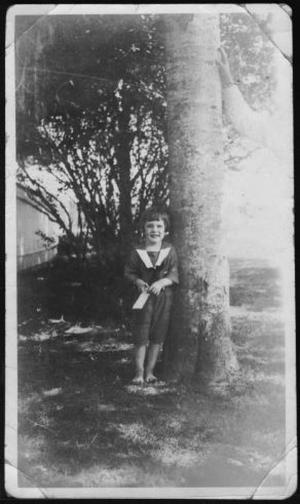 Primary view of [Photograph of Mary Jones standing next to a tree trunk]