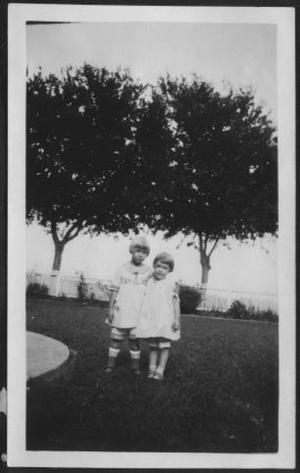 Primary view of [Photograph of Mary Jones and another young girl in the front yard of the George Ranch house]