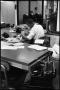 Photograph: [Man Working at Desk at Beaumont Enterprise #24]