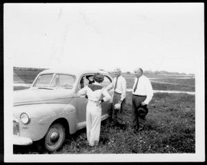 Primary view of object titled '[Mrs. Steward, Mr. A. P. George, Judge Elkins standing next to an automobile]'.