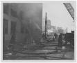 Photograph: [Firefighter's Ladders Propped Up Against Smoking Building]