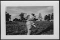 Photograph: [An unidentified man carrying a deer killed in a hunt]