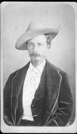 Primary view of object titled '[Albert Lamar George, seated and wearing a dark three piece suit and a hat]'.