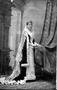 Photograph: [Woman wearing a crown and a dark fur cape lined with white fur]