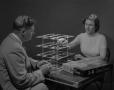 Photograph: [Man and Woman Playing with a 3-D Game Board]