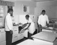 Photograph: [Two Men and a Woman in the Kitchen of the Blue Willow Tea Room]