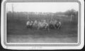 Primary view of [Four young women and two men sitting in the grass at George Ranch]