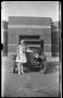 Photograph: [Photograph of Young Woman Standing with Automobile]