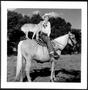 Photograph: [Outdoor photograph of a cowboy and a dog on horseback]