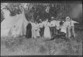 Postcard: [Eleven people standing outdoors, next to a tent]