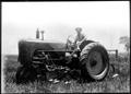 Photograph: [George Ranch farm worker sitting on the Massey Harris tractor]