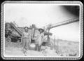 Primary view of [Two men standing near a rice thresher at the George Ranch]