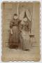 Photograph: [Photograph of Daisy and Katie Pennington in Front of a Window]