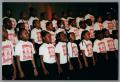 Photograph: [Young choir members singing on stage]