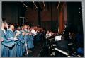 Photograph: [Choir and musicians playing together on stage]