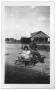 Photograph: [Young man and woman sitting on an outside chair]