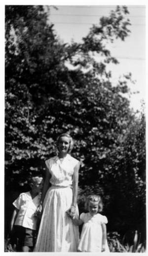 Primary view of object titled '[Barbara McCampbell and her two children standing in a yard holding hands]'.